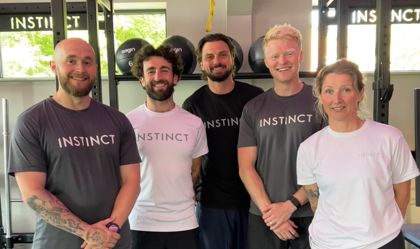 Five, friendly head coaches/person trainers with big smiles in the main gym area at Instinct Gym in Tarporley.